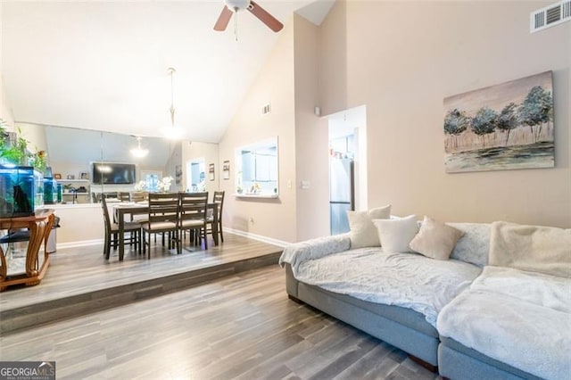 living room featuring ceiling fan, hardwood / wood-style floors, and high vaulted ceiling