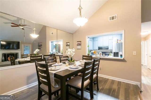 dining area featuring ceiling fan, hardwood / wood-style floors, and high vaulted ceiling