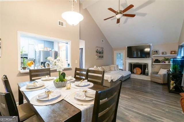 dining room with ceiling fan, high vaulted ceiling, and dark wood-type flooring