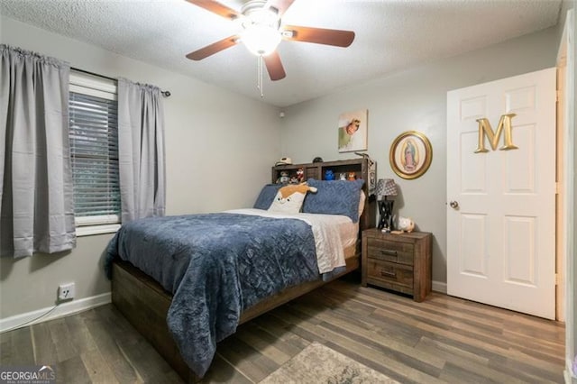 bedroom with ceiling fan, dark hardwood / wood-style flooring, and a textured ceiling