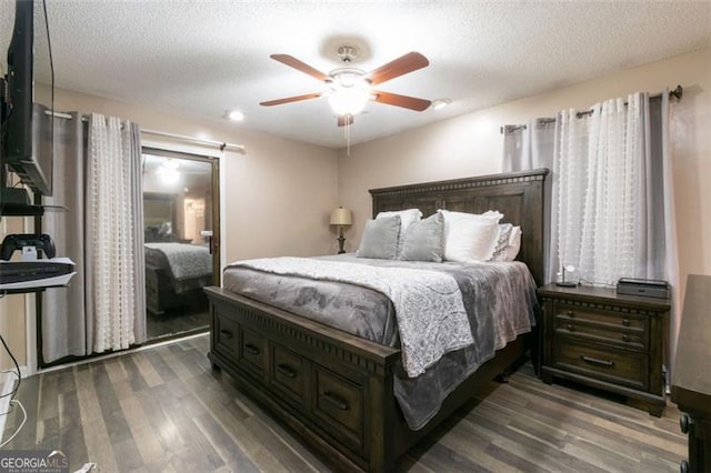 bedroom with ceiling fan, dark hardwood / wood-style floors, and a textured ceiling