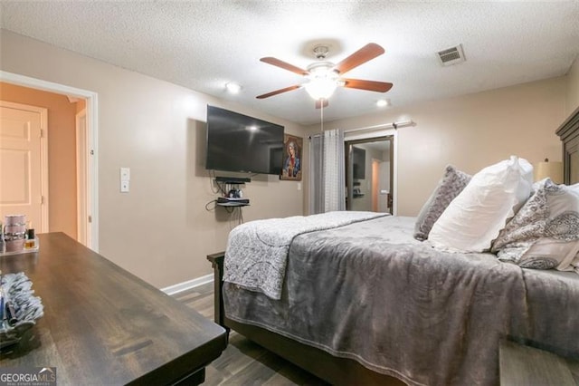 bedroom featuring a textured ceiling, ceiling fan, and dark wood-type flooring