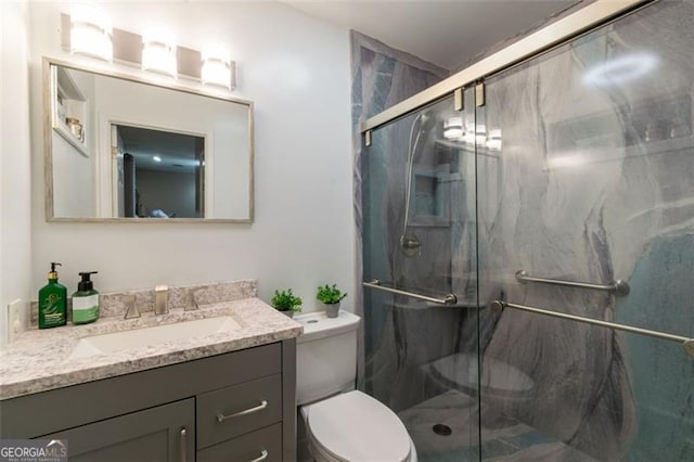 bathroom with vanity, toilet, and a shower with door