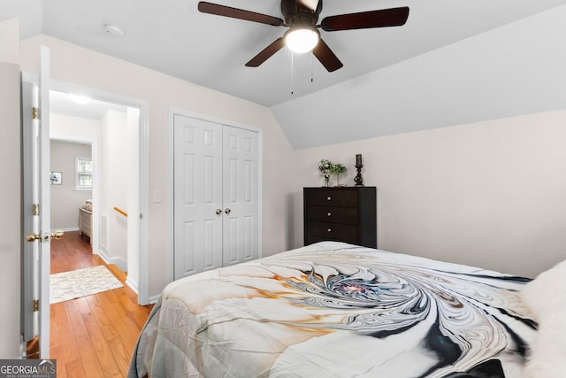 bedroom with wood-type flooring, a closet, vaulted ceiling, and ceiling fan