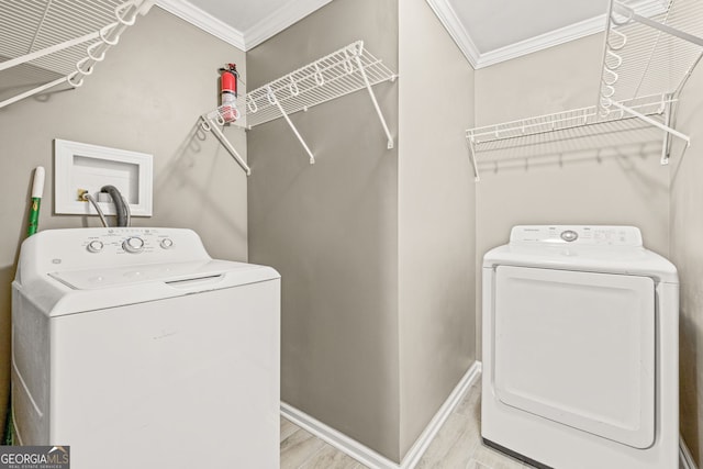 laundry area featuring washer and dryer, light hardwood / wood-style floors, and crown molding