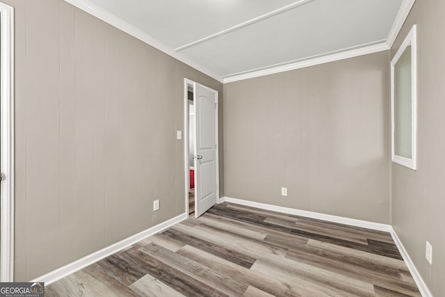 spare room with ornamental molding and hardwood / wood-style flooring