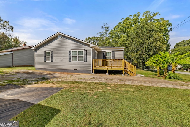 rear view of house with a lawn and a wooden deck