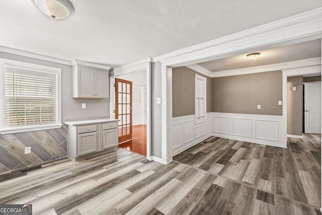 interior space with crown molding and light hardwood / wood-style flooring