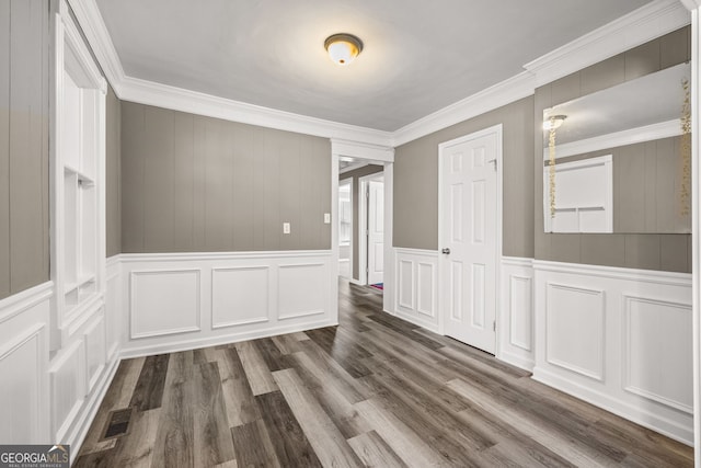 spare room featuring ornamental molding and dark wood-type flooring