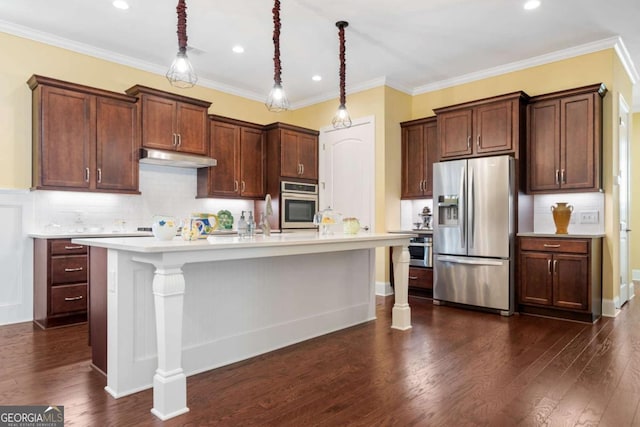 kitchen featuring stainless steel appliances, dark hardwood / wood-style floors, ornamental molding, and an island with sink