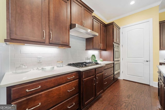 kitchen with backsplash, dark wood-type flooring, ornamental molding, appliances with stainless steel finishes, and dark brown cabinets