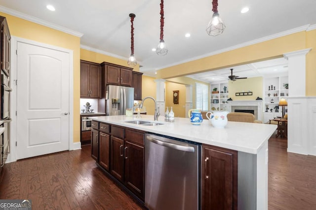 kitchen with hanging light fixtures, sink, ceiling fan, an island with sink, and appliances with stainless steel finishes