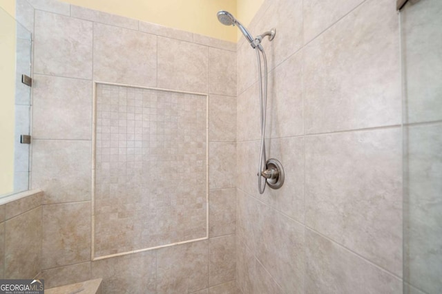 interior details featuring a tile shower