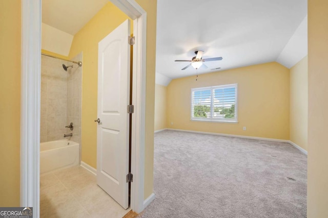 bathroom with ceiling fan, tiled shower / bath combo, and lofted ceiling