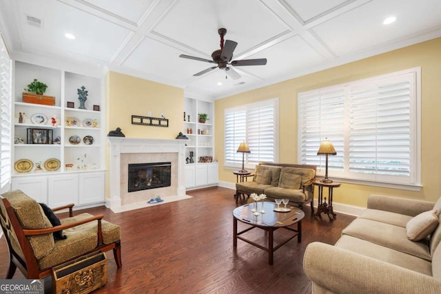 living room with built in shelves, dark wood-type flooring, ceiling fan, and coffered ceiling