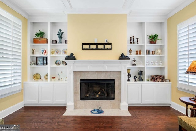 living room featuring a tile fireplace, built in shelves, and dark wood-type flooring