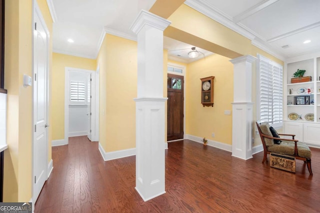 hall with dark hardwood / wood-style floors, built in features, crown molding, and ornate columns