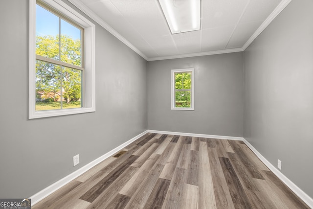 empty room featuring hardwood / wood-style floors and ornamental molding