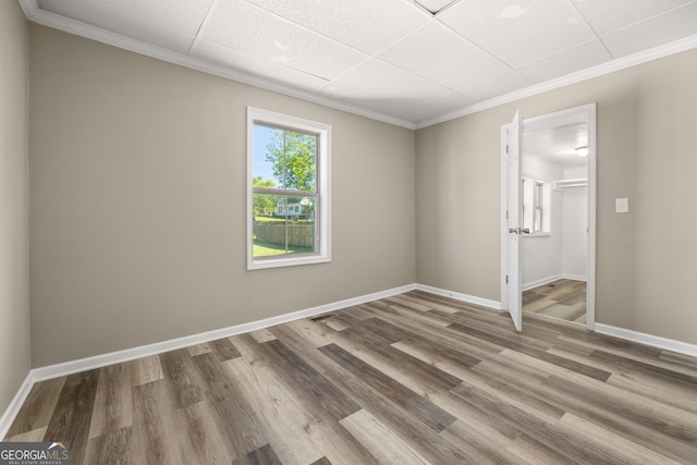 unfurnished room with a paneled ceiling, plenty of natural light, and hardwood / wood-style floors