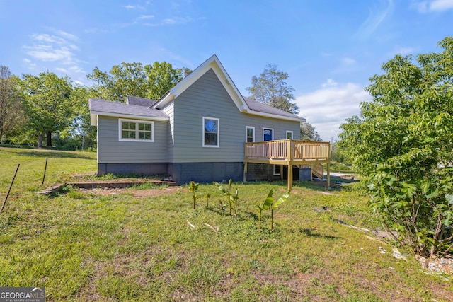 rear view of property with a deck and a yard