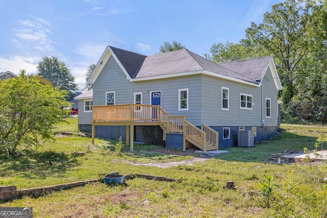 rear view of house featuring central air condition unit, a wooden deck, and a yard