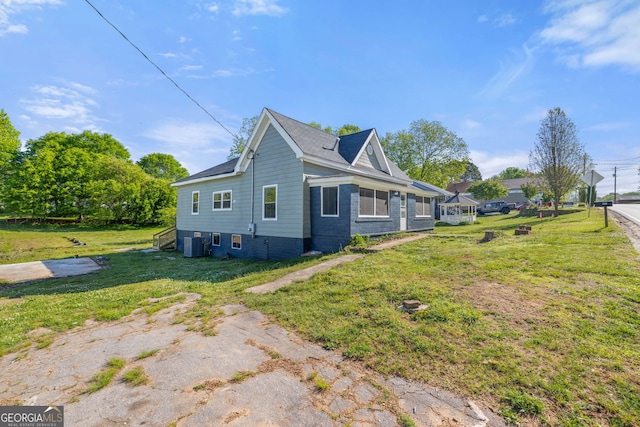 view of home's exterior featuring a lawn and central AC unit