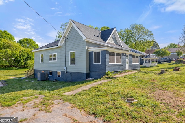 view of side of property with a lawn and central air condition unit