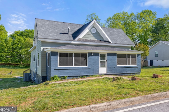 view of front of house with central AC unit and a front lawn