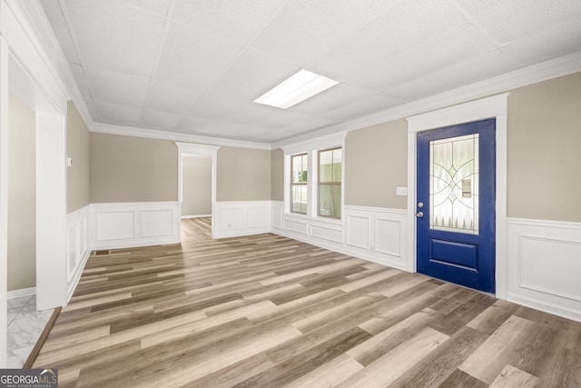 foyer entrance featuring a drop ceiling, wood-type flooring, and crown molding