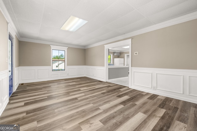 unfurnished room featuring wood-type flooring and ornamental molding