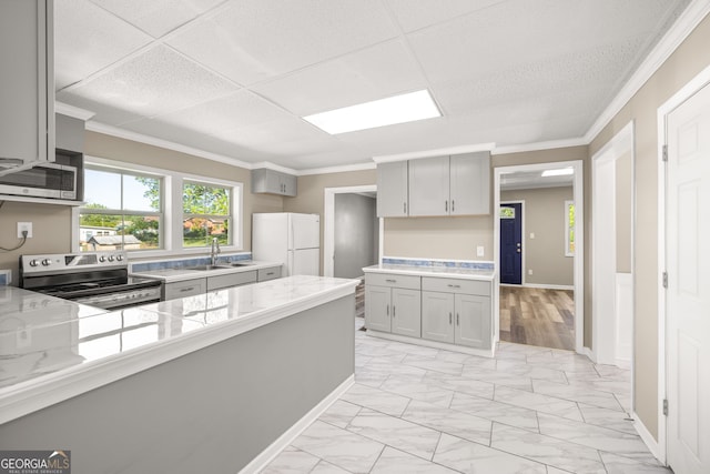 kitchen with a paneled ceiling, stainless steel appliances, gray cabinetry, and sink