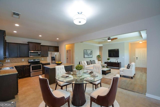 dining space with ceiling fan and sink