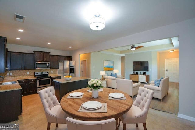 dining room featuring ceiling fan and sink