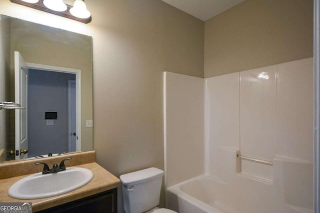 full bathroom featuring washtub / shower combination, vanity, and toilet