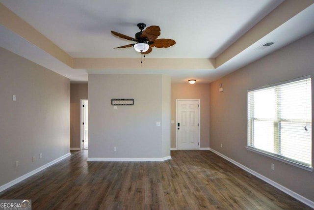 empty room with ceiling fan and dark hardwood / wood-style flooring