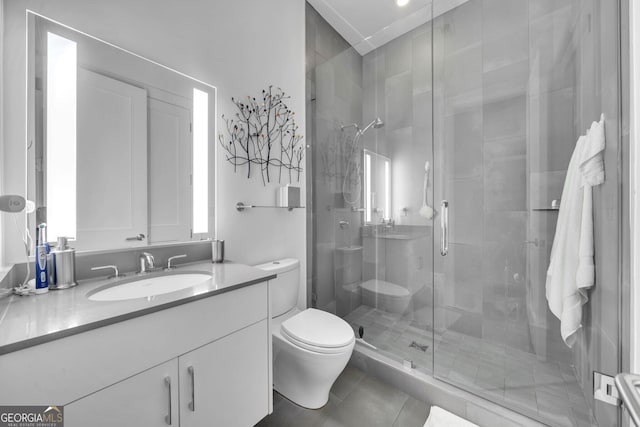 bathroom featuring tile patterned flooring, vanity, toilet, and a shower with door