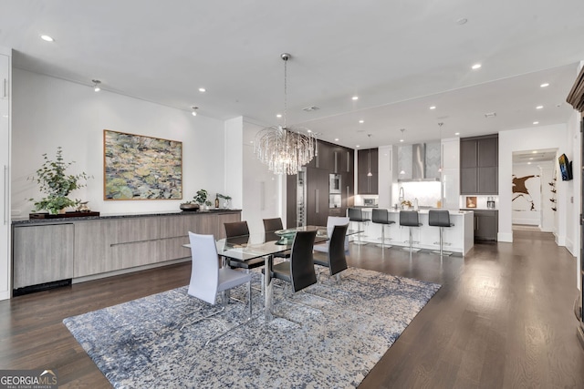 dining room with sink, dark hardwood / wood-style floors, and an inviting chandelier