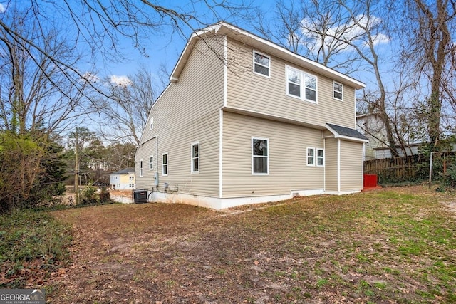 back of house featuring a lawn and central AC