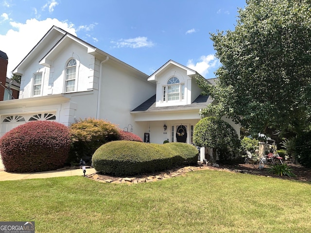 view of property featuring a front lawn and a garage