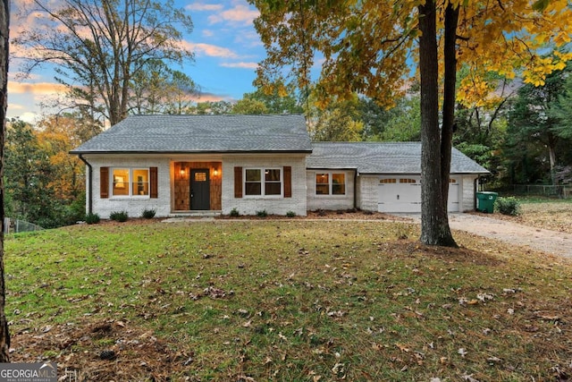 single story home featuring a lawn and a garage