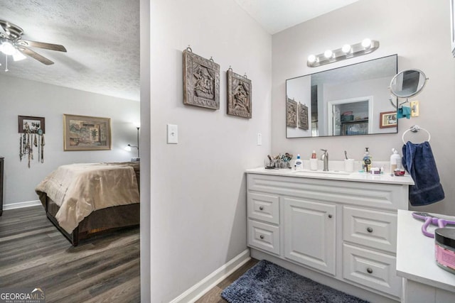 bathroom featuring vanity, hardwood / wood-style floors, a textured ceiling, and ceiling fan