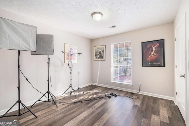 spare room with dark wood-type flooring and a textured ceiling