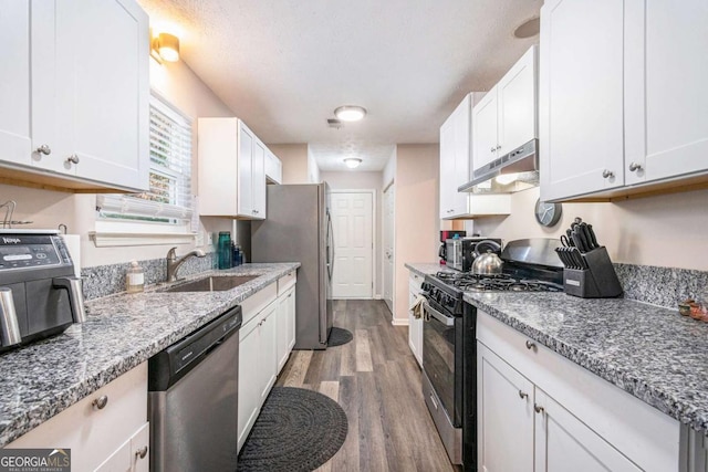 kitchen featuring white cabinets, appliances with stainless steel finishes, hardwood / wood-style floors, and sink