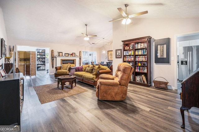 living room with hardwood / wood-style flooring, a textured ceiling, and vaulted ceiling