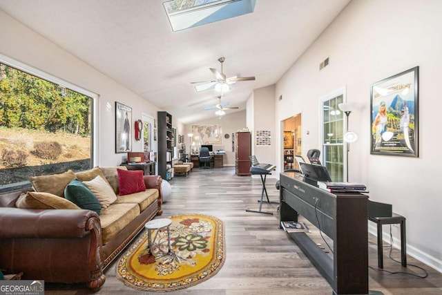 1276 Westover Trce NW, Acworth, GA 30102 - living room featuring vaulted ceiling, wood finished floors, a ceiling fan, and a skylight