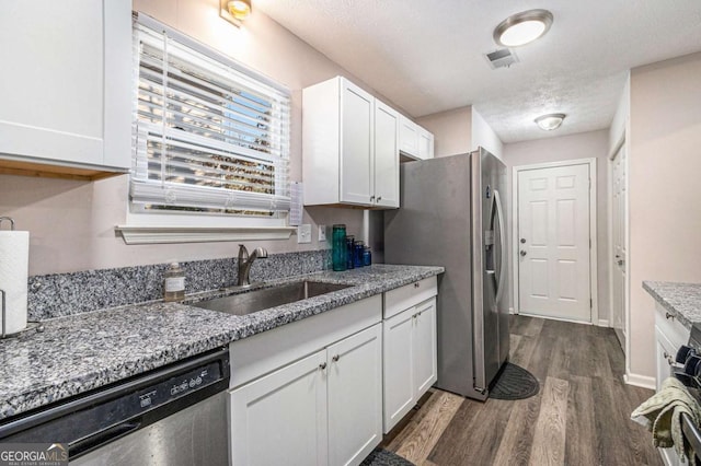 kitchen featuring sink, dark hardwood / wood-style flooring, light stone counters, white cabinetry, and stainless steel appliances