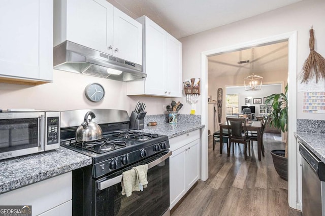 kitchen with white cabinetry, dark hardwood / wood-style flooring, light stone counters, and appliances with stainless steel finishes