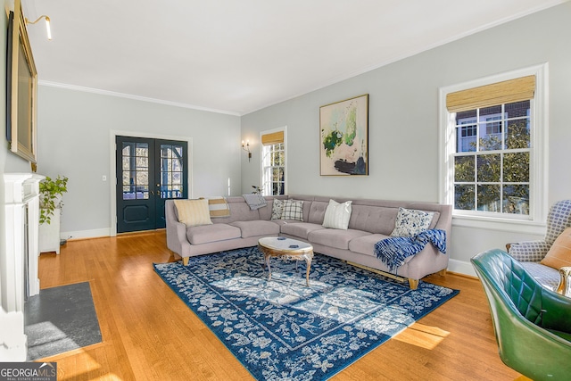 living room with hardwood / wood-style floors, ornamental molding, and french doors