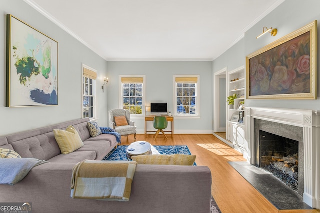 living room featuring built in features, ornamental molding, a high end fireplace, and light hardwood / wood-style flooring