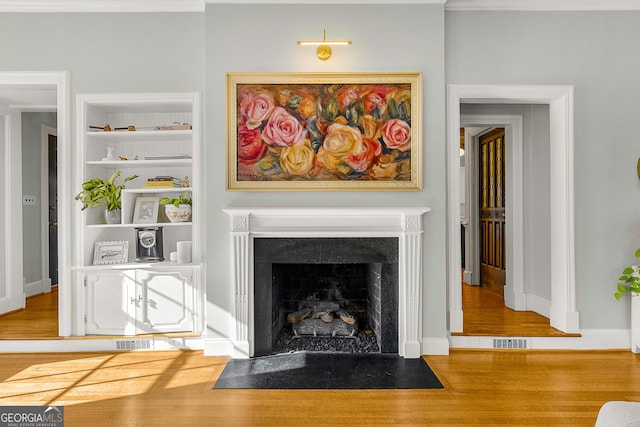 living room featuring wood-type flooring and built in features